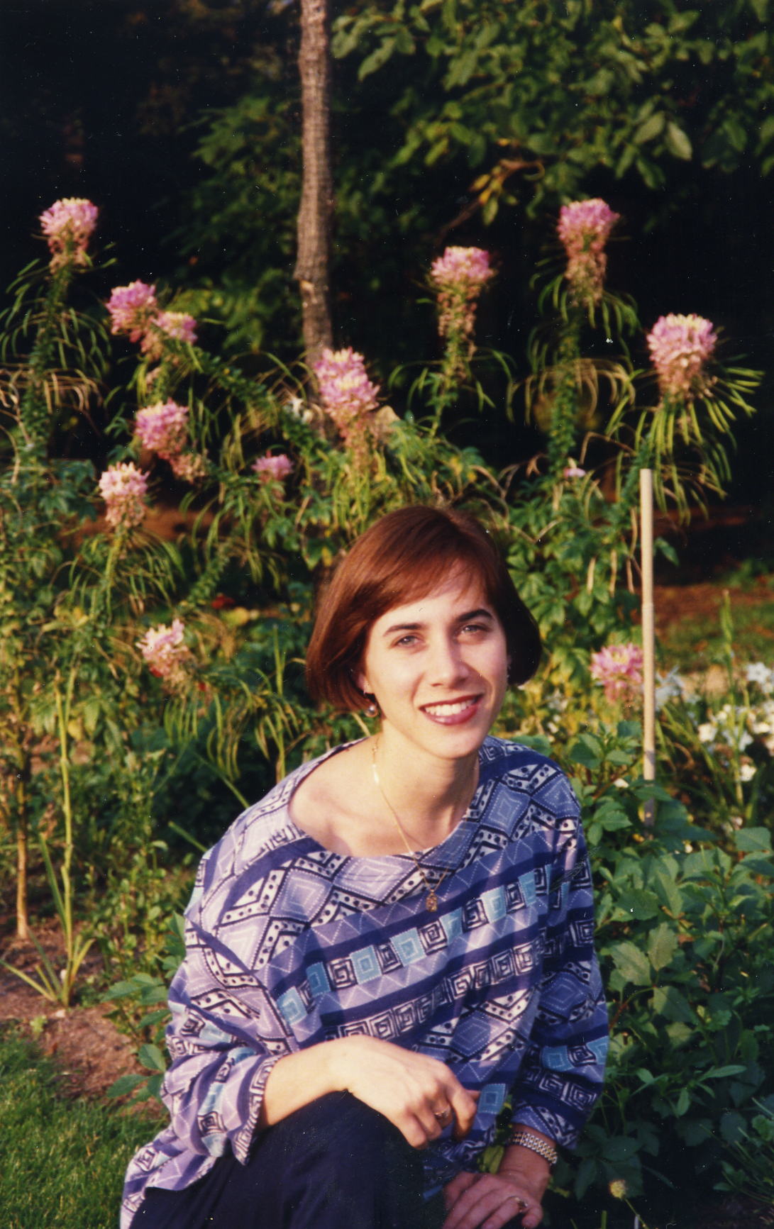 The same person grown up, smiling in a garden